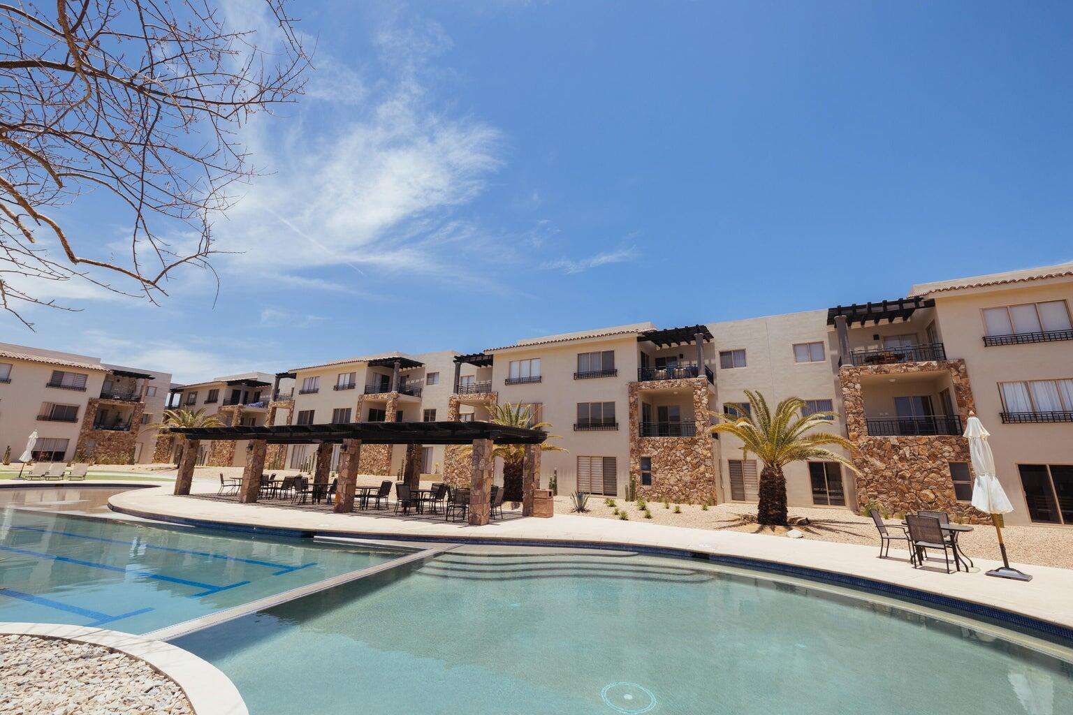 Los Cabos Cora One of the lowest-priced furnished residences currently available in Cora, this 2024-built condo is move-in ready and located within Club Campestre in San José del Cabo. The floor plan offers 3 bedrooms and 3.5 baths with approximately 1,841 sq ft of interior living space. Bright, modern interiors feature large-format tile flooring, an open-concept kitchen with island seating, and expansive sliding glass doors that connect seamlessly to oversized private decks. The interior design emphasizes clean lines, neutral finishes, and a cohesive open layout that connects the kitchen, dining, and living areas into a single, light-filled space. The kitchen is centered around a large island with quartz-style surfaces, modern cabinetry, and pendant lighting, opening directly to the main living area for easy entertaining. Floor-to-ceiling sliding glass doors extend the living space outdoors, creating a strong indoor-outdoor connection and allowing natural light to flow throughout the residence.Living and dining areas are furnished with contemporary pieces scaled appropriately for the space, complementing the modern architectural style seen throughout the development. Bedrooms are well-proportioned and designed for privacy, while bathrooms feature glass-enclosed showers and streamlined finishes consistent with the home's overall aesthetic. Privacy blinds, LED televisions with integrated switching, and thoughtfully placed lighting add functionality while maintaining a clean visual profile.Outdoor living areas are a standout feature, with expansive decks and patios offering generous space for seating, dining, and relaxation while overlooking the community's architectural landscaping and surrounding natural terrain.. Two covered on-property parking spaces include electricity and water connections suitable for electric vehicle charging or vehicle washing, and a private 10x10x14 storage locker with electricity provides secure owner storage.Cora is a gated, master-planned community within Campestre San José, featuring contemporary architecture and resort-style amenities visible throughout the property. Community offerings include a large swimming pool with integrated lounging areas, a hot tub, fitness center, indoor children's play area, and an enclosed dog park, all supported by 24/7 security. The Campestre San José golf course is approximately 0.5 miles away, and the private beach club on the Sea of Cortez is roughly 2.5 miles from the residence, subject to membership terms.Dining, recreation, and services are easily accessible, with Flora Farms approximately 2.8 miles away, Acre Restaurant about 3.0 miles, and the Historic Art District of downtown San José del Cabo roughly 4.5 miles from the property. Beachfront dining along the Tourist Corridor, including venues such as Veleros Beach Club and 7 Seas Grille & Seafood, is approximately 6.5 miles away, while Los Cabos International Airport is about 10.5 miles from the residence.Offered fully furnished and... for sale